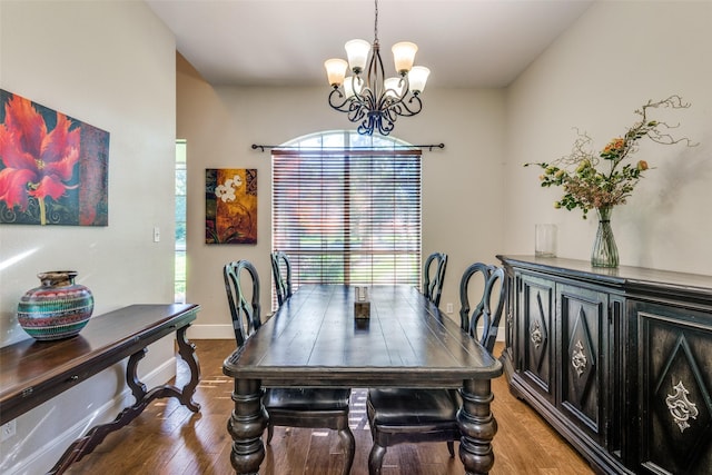 dining space featuring hardwood / wood-style flooring and an inviting chandelier