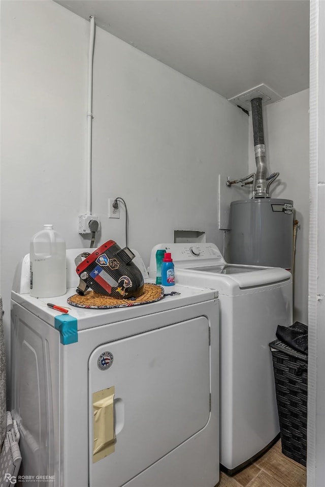 washroom with washer and clothes dryer, light wood-type flooring, and water heater