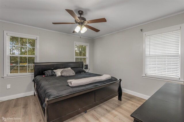 bedroom with ceiling fan, light wood-type flooring, and crown molding