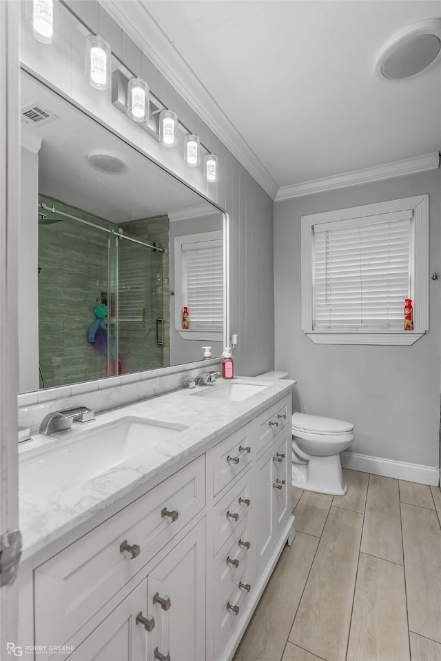 bathroom featuring vanity, a shower with door, crown molding, toilet, and wood-type flooring