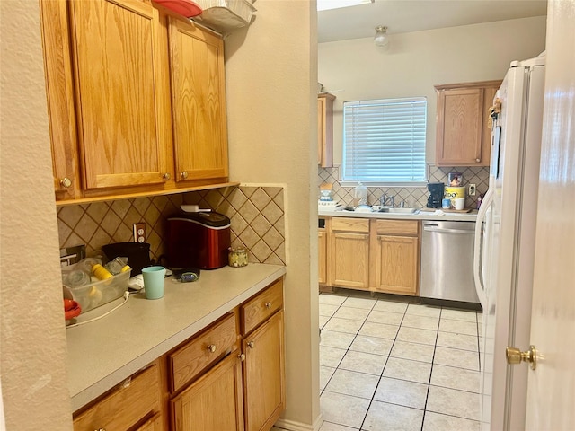 kitchen featuring decorative backsplash, sink, white refrigerator, dishwasher, and light tile patterned flooring