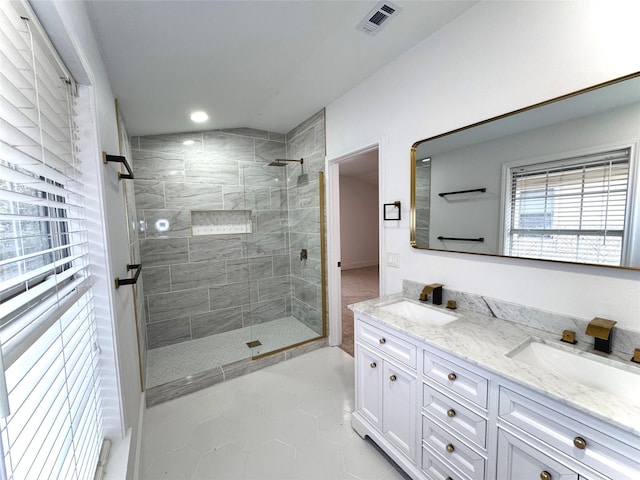 bathroom with tile patterned floors, vanity, and a tile shower