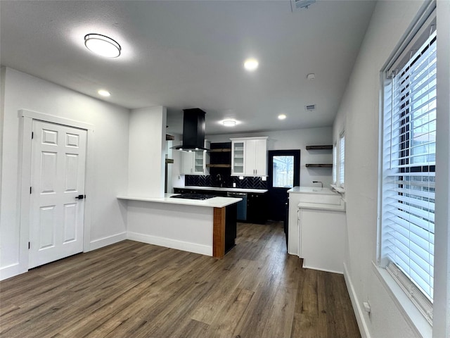 kitchen featuring white cabinetry, backsplash, dark hardwood / wood-style flooring, island exhaust hood, and kitchen peninsula