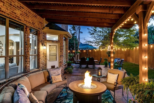 patio terrace at dusk with an outdoor living space with a fire pit