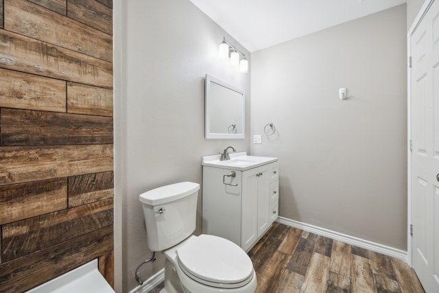 bathroom with toilet, vanity, and hardwood / wood-style flooring