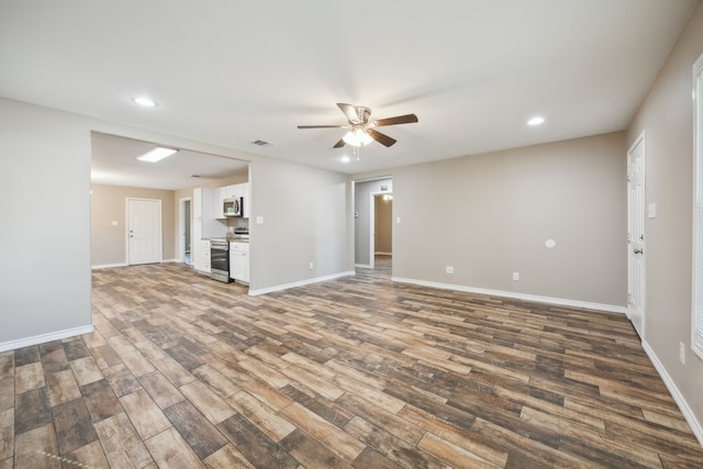 unfurnished living room featuring ceiling fan and dark wood-type flooring