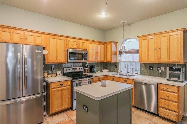 kitchen with appliances with stainless steel finishes, decorative light fixtures, tasteful backsplash, sink, and a center island