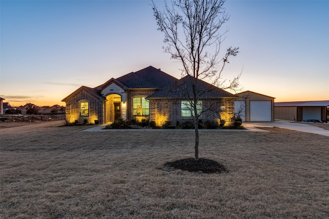 view of front of property featuring a garage, an outdoor structure, and a yard