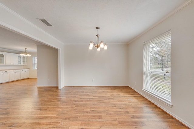 interior space with a notable chandelier, crown molding, and light hardwood / wood-style flooring