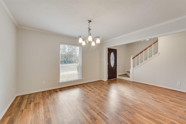 entryway with an inviting chandelier, light hardwood / wood-style flooring, and crown molding