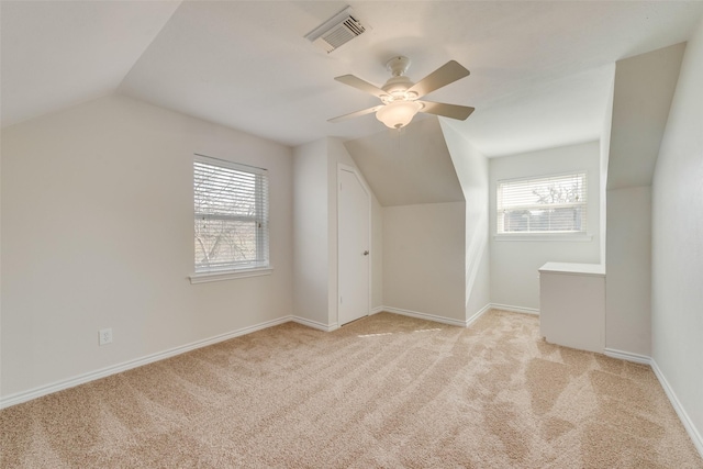 additional living space with ceiling fan, lofted ceiling, light carpet, and a wealth of natural light