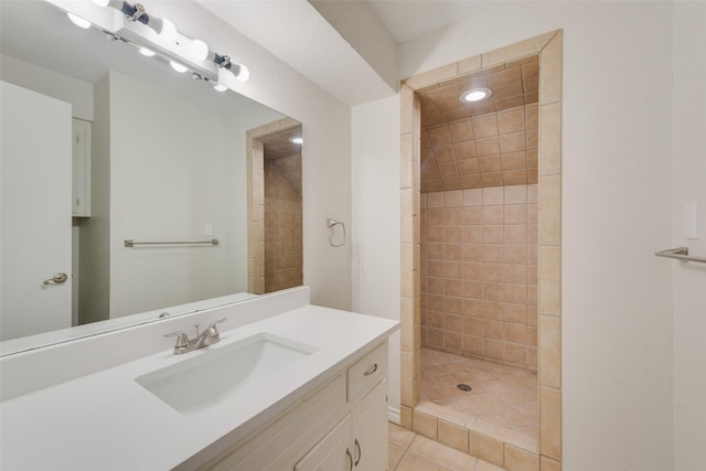 bathroom with tile patterned flooring, vanity, and tiled shower