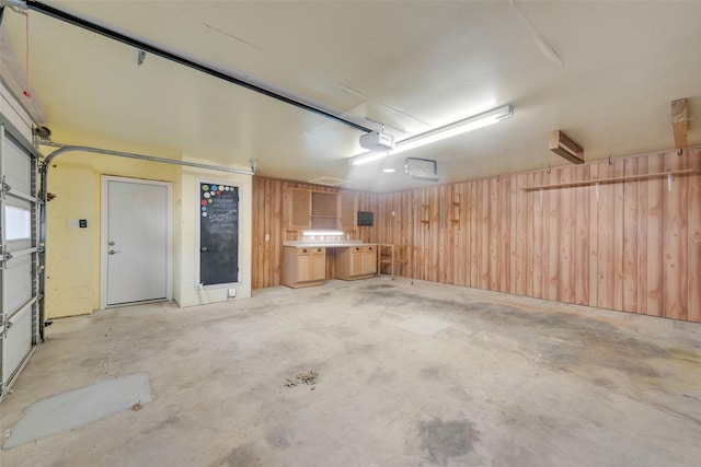 garage featuring a garage door opener and wooden walls