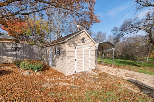 view of outbuilding with a carport and a lawn