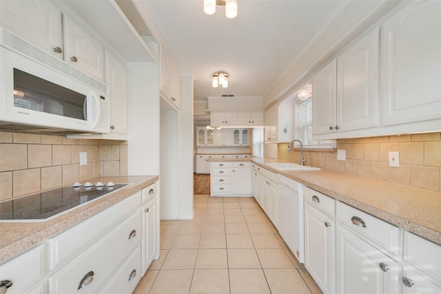 kitchen featuring decorative backsplash, white cabinetry, white appliances, and sink