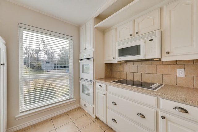 kitchen featuring plenty of natural light, white cabinets, and white appliances