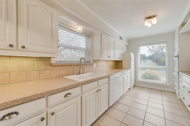 kitchen featuring white cabinetry, sink, backsplash, white appliances, and light tile patterned flooring