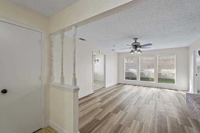 interior space featuring a textured ceiling, light wood-type flooring, and ceiling fan