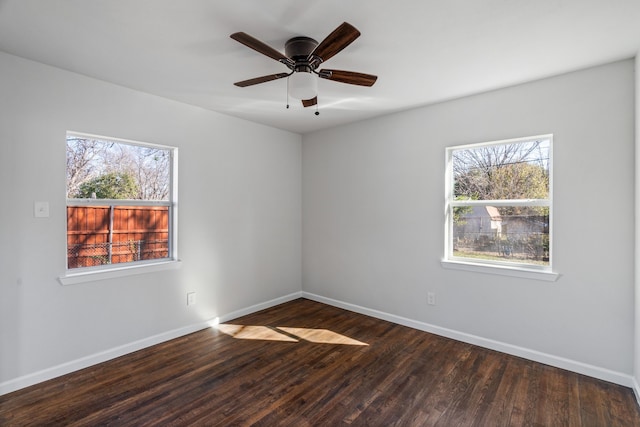 spare room featuring dark hardwood / wood-style flooring, ceiling fan, and a healthy amount of sunlight