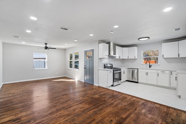 kitchen featuring sink, ceiling fan, appliances with stainless steel finishes, light hardwood / wood-style floors, and white cabinetry