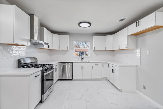 kitchen featuring sink, white cabinets, stainless steel appliances, and wall chimney range hood