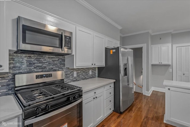 kitchen with white cabinets, ornamental molding, tasteful backsplash, dark hardwood / wood-style flooring, and stainless steel appliances