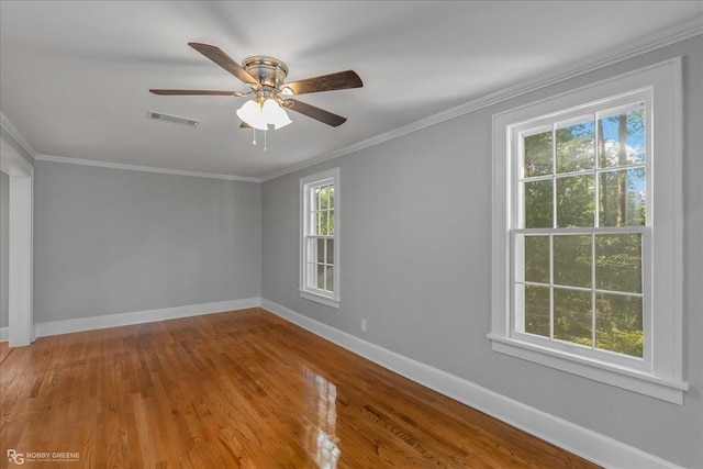 spare room with wood-type flooring, plenty of natural light, ornamental molding, and ceiling fan