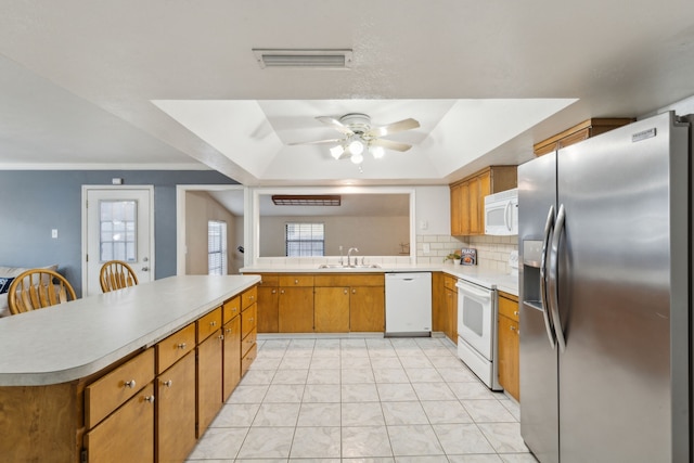 kitchen featuring ceiling fan, white appliances, sink, and a wealth of natural light