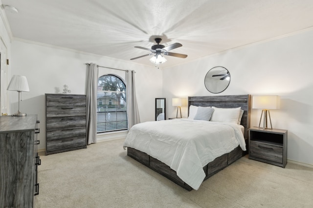 carpeted bedroom featuring ceiling fan and crown molding