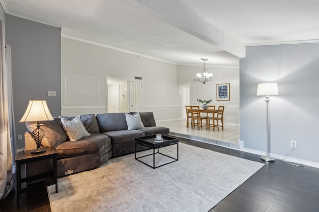 living room featuring hardwood / wood-style floors, vaulted ceiling, ornamental molding, and a chandelier