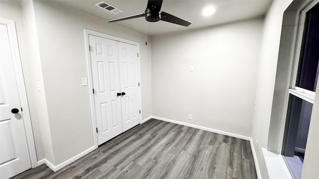 unfurnished bedroom with hardwood / wood-style floors, ceiling fan, and a closet