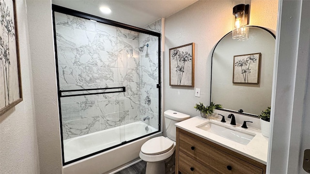 full bathroom featuring toilet, vanity, and bath / shower combo with glass door