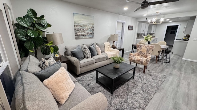 living room with ceiling fan and light hardwood / wood-style floors