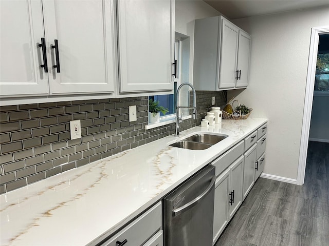 kitchen featuring tasteful backsplash, sink, white cabinets, dark hardwood / wood-style flooring, and stainless steel dishwasher