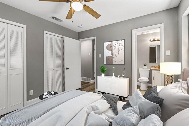 bedroom featuring ensuite bathroom, ceiling fan, dark hardwood / wood-style floors, and multiple closets