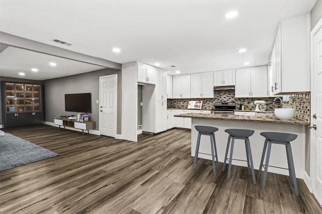 kitchen featuring white cabinets, electric range, dark hardwood / wood-style floors, stone countertops, and kitchen peninsula