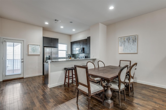 dining area featuring sink and dark wood-type flooring