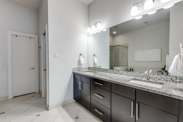 bathroom with tile patterned flooring, vanity, and walk in shower