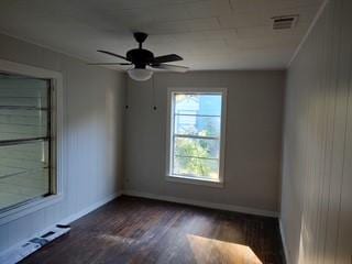 empty room featuring dark hardwood / wood-style floors, ceiling fan, and baseboard heating