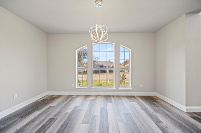 unfurnished dining area featuring wood-type flooring and a chandelier