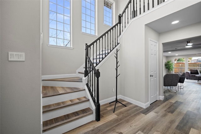 stairway with ceiling fan and hardwood / wood-style flooring