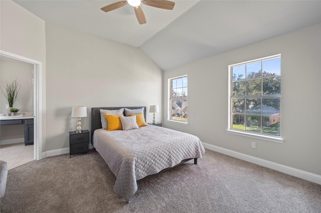 bedroom featuring ceiling fan, lofted ceiling, connected bathroom, and light carpet