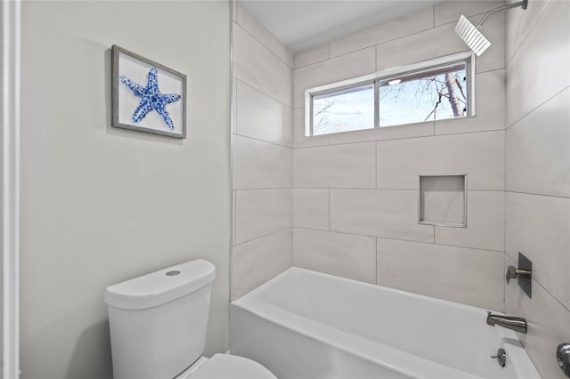 bathroom with tiled shower / bath combo and toilet