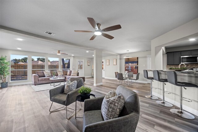 living room with ceiling fan and light hardwood / wood-style floors