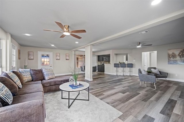 living room with dark wood-type flooring and ceiling fan