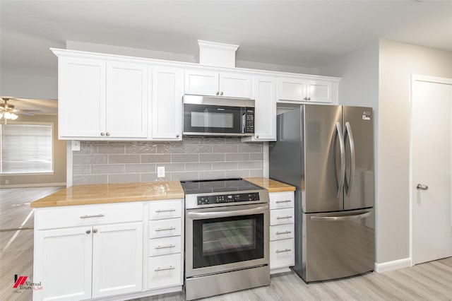 kitchen with light wood-type flooring, white cabinetry, appliances with stainless steel finishes, and wooden counters