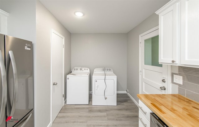 washroom with washer and dryer and light wood-type flooring