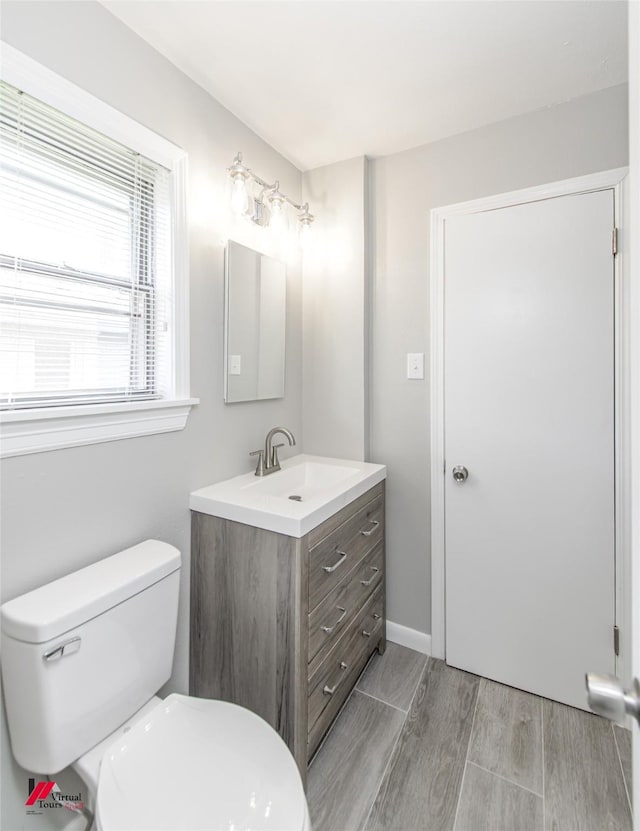 bathroom featuring vanity, hardwood / wood-style flooring, and toilet