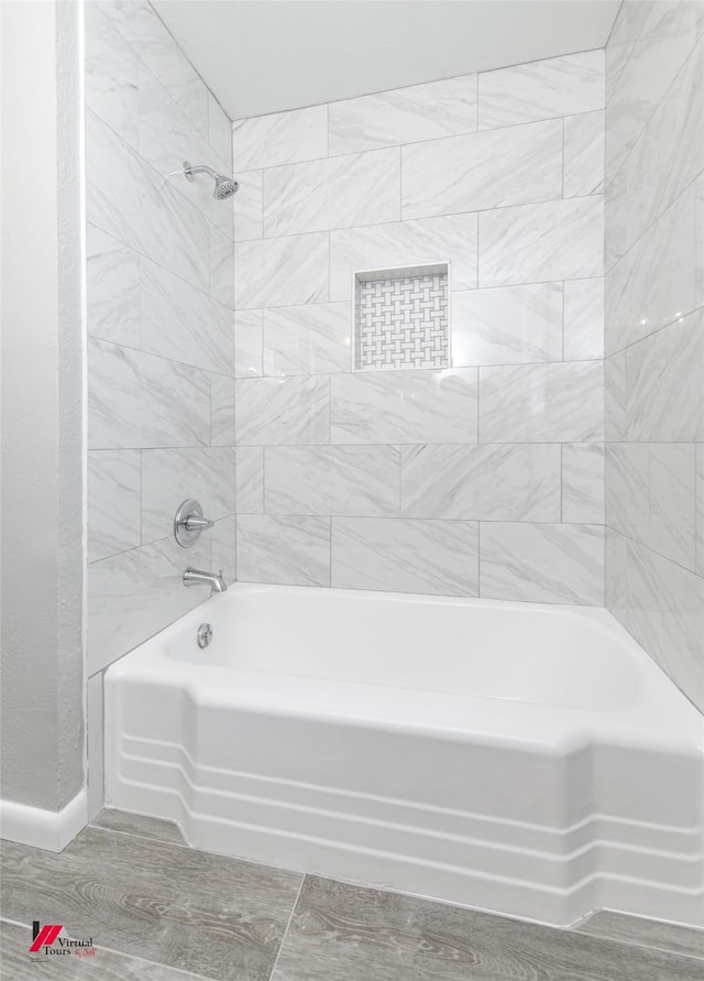 bathroom with hardwood / wood-style floors and tiled shower / bath combo