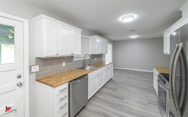 kitchen with white cabinetry, sink, wooden counters, and appliances with stainless steel finishes